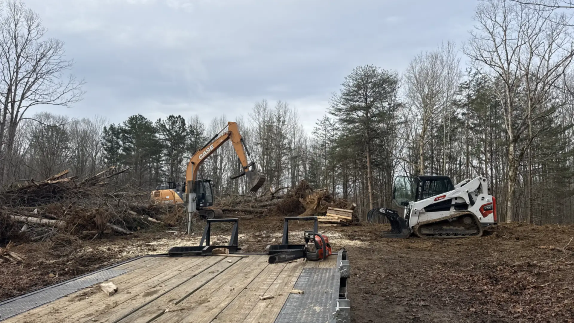 Boundless Excavation excavator and skid steer working a cleared site with timber equipment mats near Chattanooga, TN